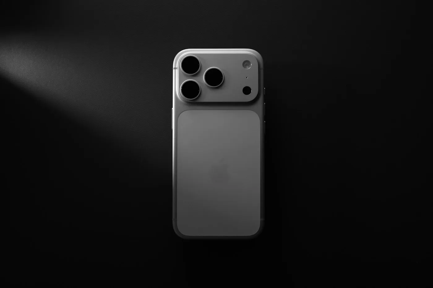 iPhone visto por detrás sobre fondo negro